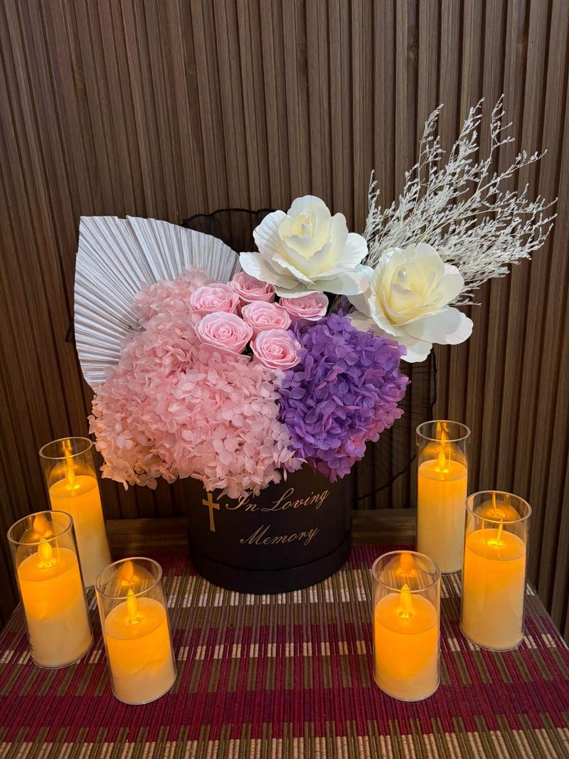 Pink roses with pink and purple hydrangea in a black box marked In Loving Memory