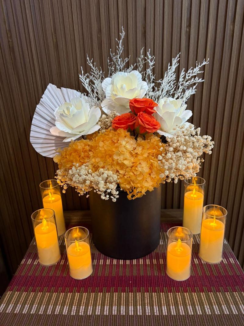 Orange roses and peach hydrangea in a plain black box