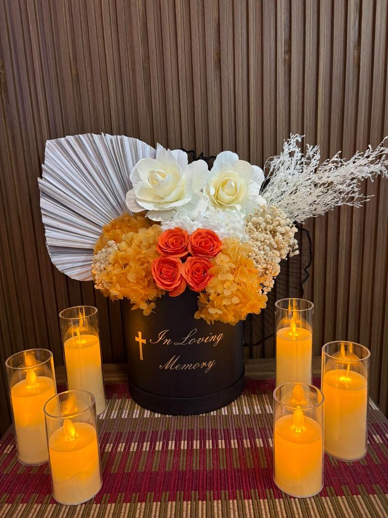 Orange roses and orange hydrangea in a black box marked In Loving Memory