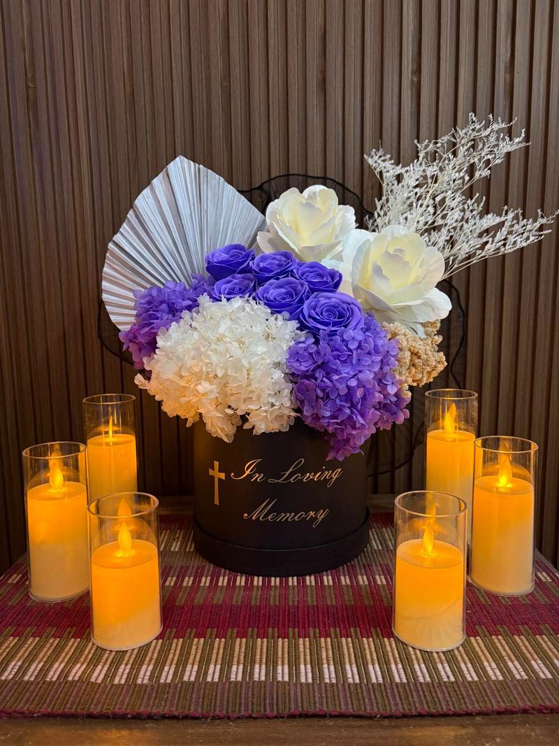 Purple roses with purple and white hydrangea in a black box marked In Loving Memory