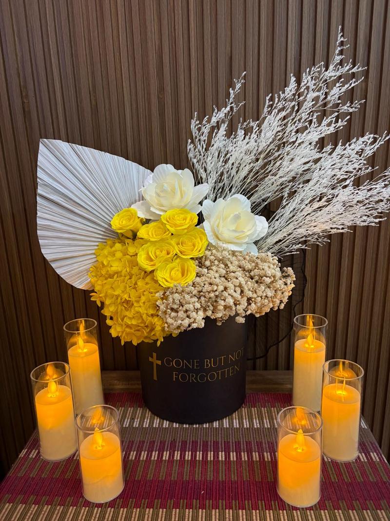 Yellow roses and yellow hydrangea in a black box marked Gone But Not Forgotten